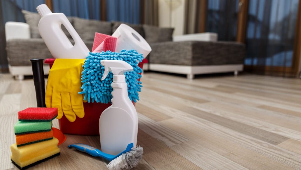 spring cleaning supplies on hardwood floor bucket mop spray bottle